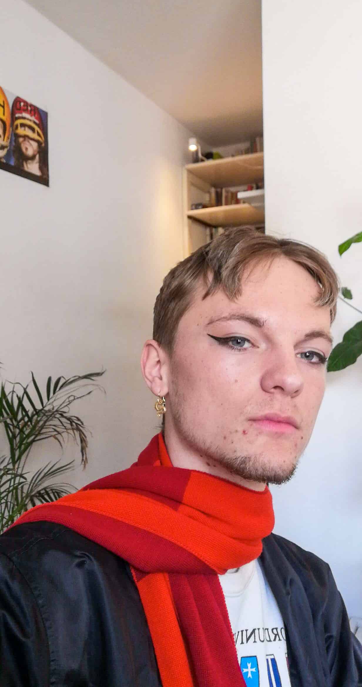 A man with a red scarf wearing a vegan eyeliner