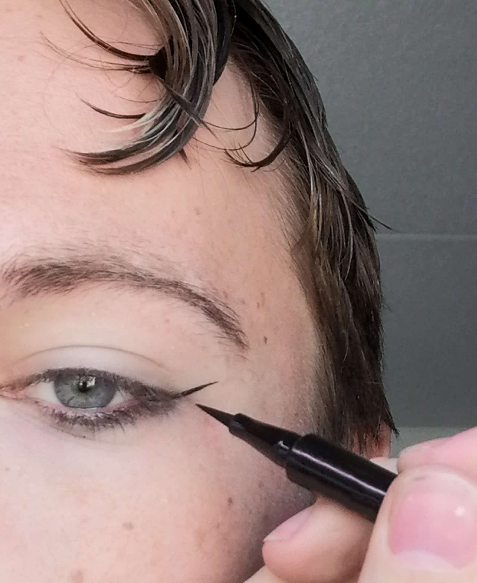 A man demonstrating how to apply a cruelty-free black eyeliner
